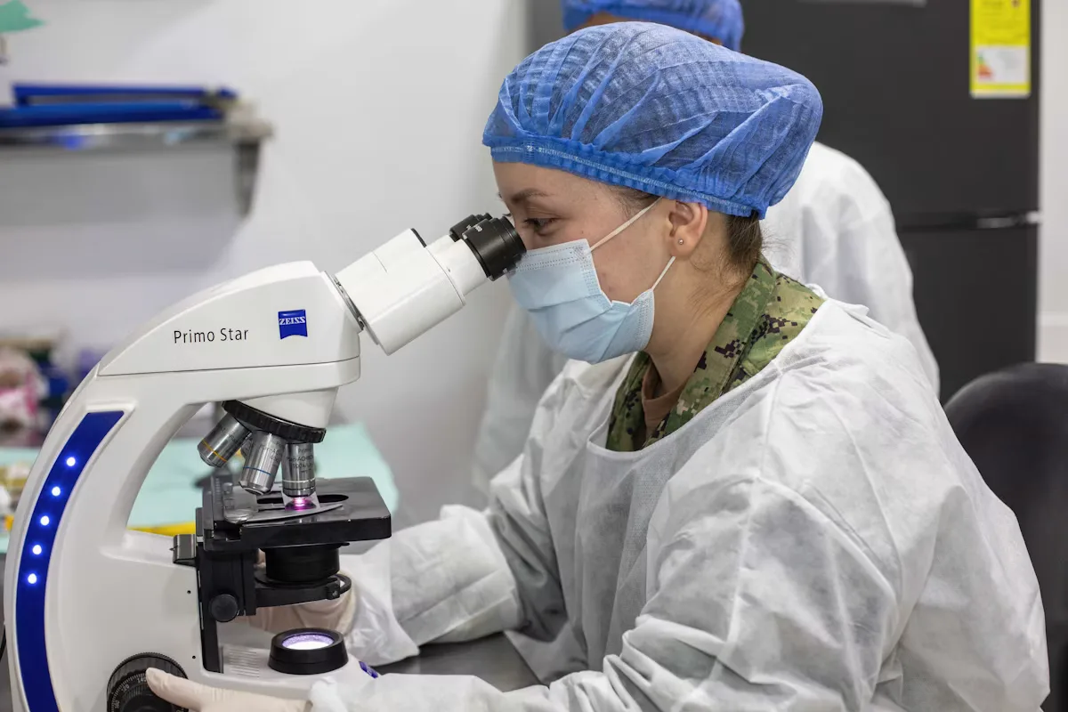 Laboratory researcher examining a sample through a microscope during a clinical research study
